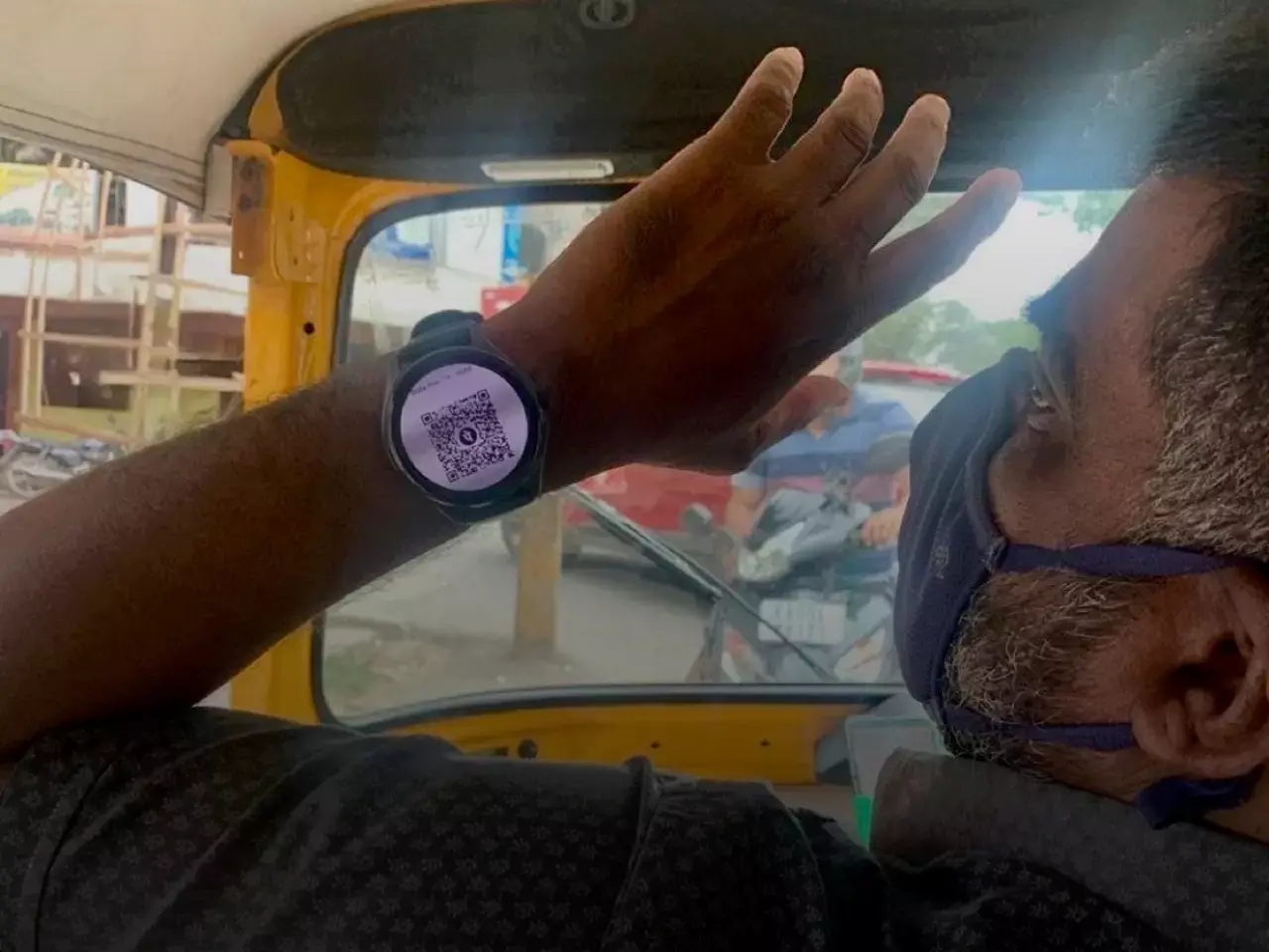 auto driver accepting payment via qr code on smart watch
