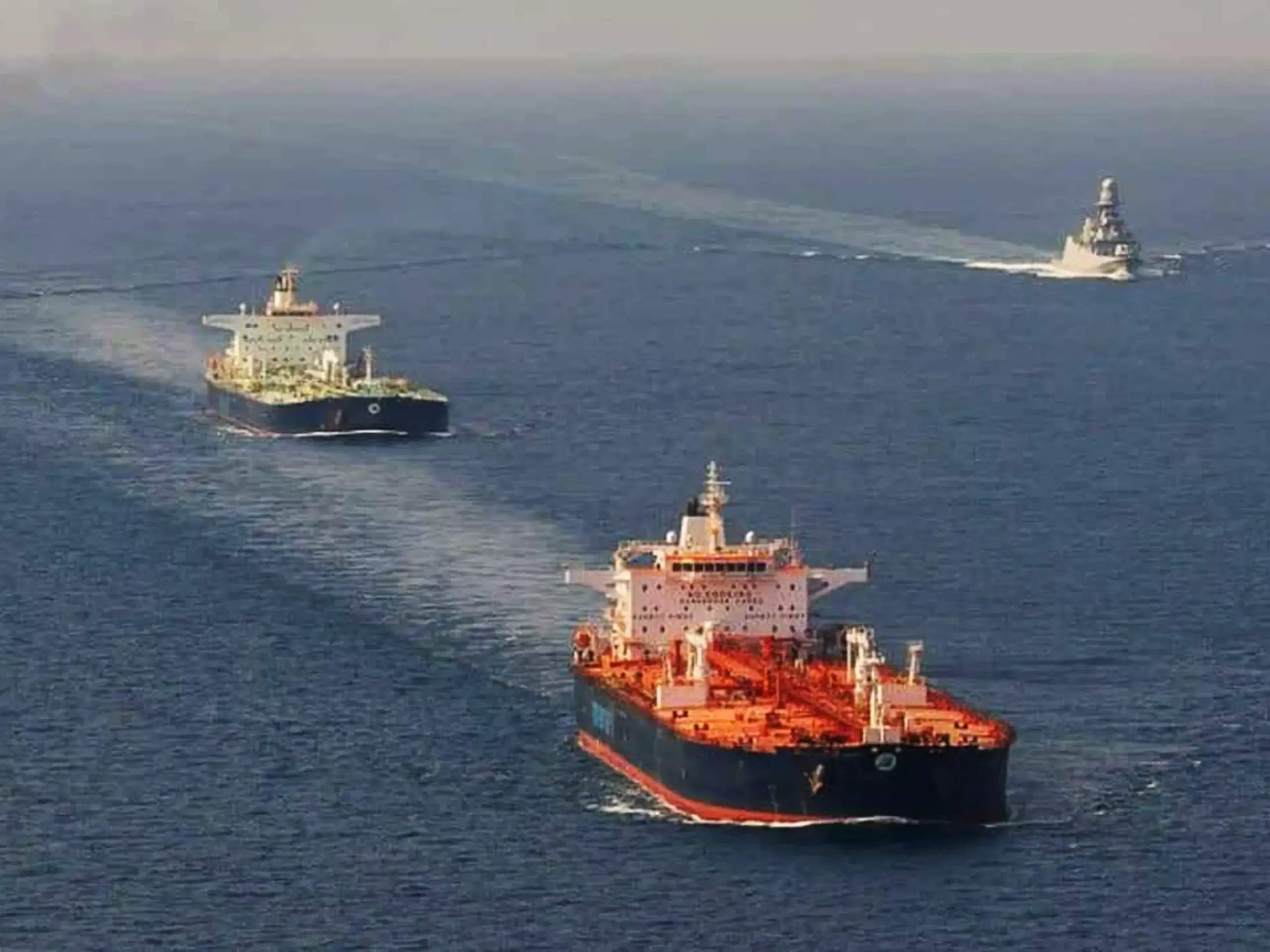 Map showing Strait of Hormuz with oil tankers and flags of USA and Iran representing the naval blockade.